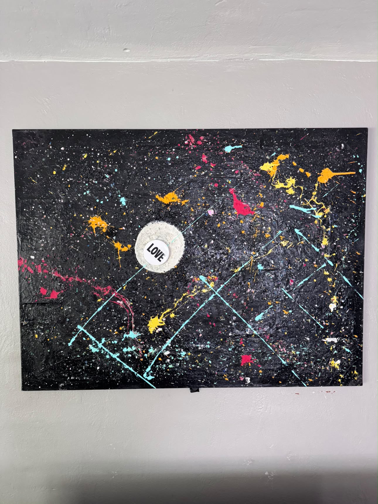Black canvas with splattered colour and a LOVE detail